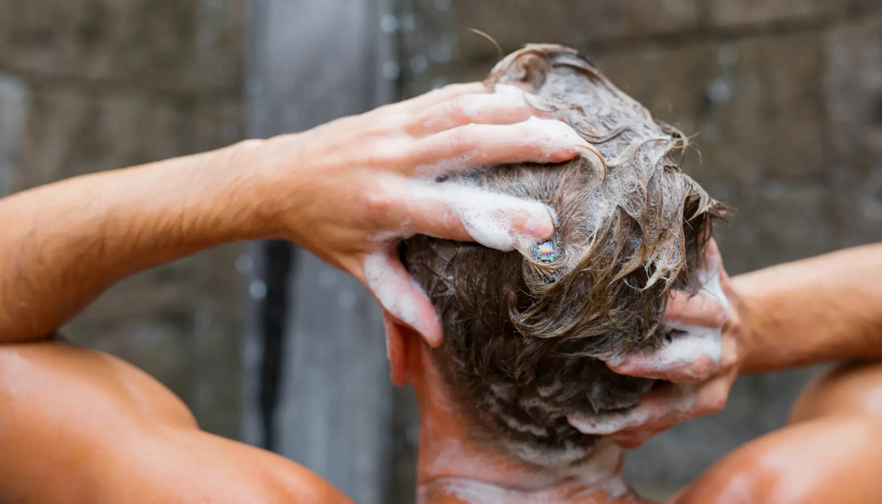 Person washing hair with anti dandruff shampoo